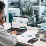 工場を見ながら原価管理ダッシュボードを確認する管理者