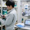 部品棚でスマホを使い在庫を確認する製造業の作業者